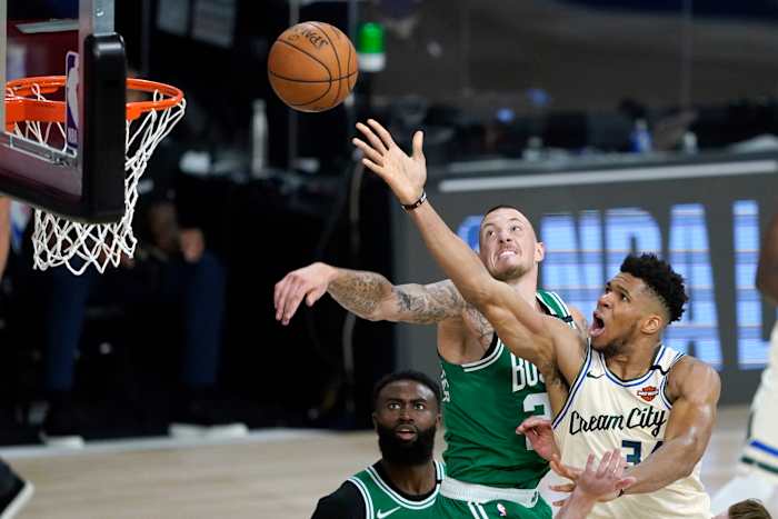 Milwaukee Bucks' Giannis Antetokounmpo, right, heads to the basket as Boston Celtics' Daniel Theis defends during the second half of an NBA basketball game Friday, July 31, 2020,